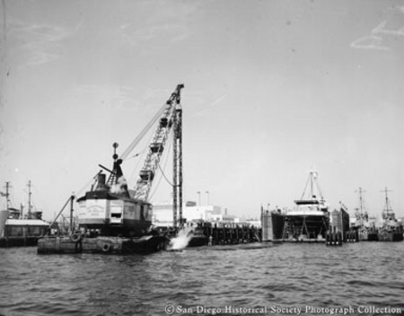 View of San Diego waterfront showing pile driver and tuna boat White Star in drydock