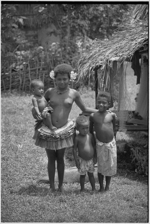 Adolescent girl wearing short fiber skirt, with other younger children
