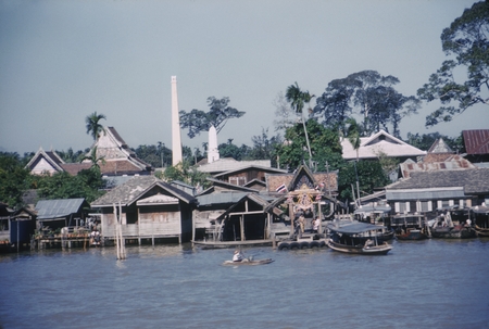Boat moored in front of temple - homes along waterfront