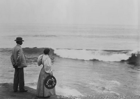Man and woman watching ocean surf [at La Jolla beach?]