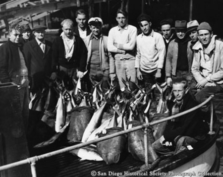 Group portrait of fishermen posing with catch