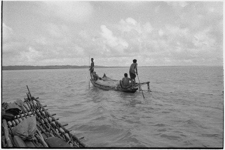 Canoes: men use poles to move small outrigger, detail of another canoe&#39;s platform in foreground