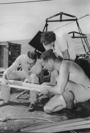 Milton Nunn Bramlette (sitting) and Roger Revelle are carefully remove a core sample aboard R/V Spencer F. Baird
