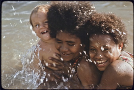 Young women taking care of an Australian child named Butch Holland, enjoying a swim