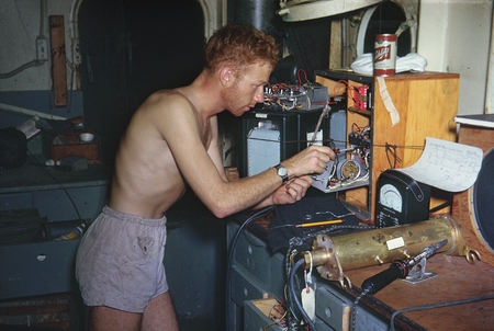 Oceanographer Alan Churchill Jones during the Capricorn Expedition (1952-1953), shown here working on a wave recorder. Thi...
