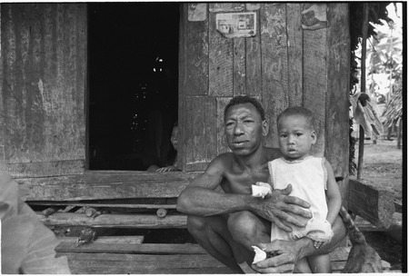 Man and infant sit on steps, sharing food