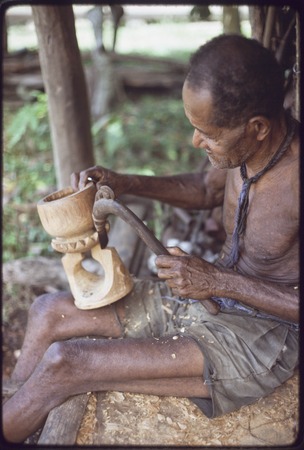 Carving: M&#39;lapokala carving a bowl, probably for tourist trade, he uses an awl with carved wooden handle