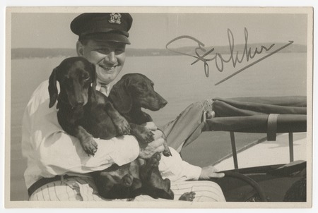 Man with two dachshunds on a boat
