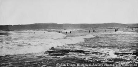 Distant view of people wading in ocean surf at Ocean Beach
