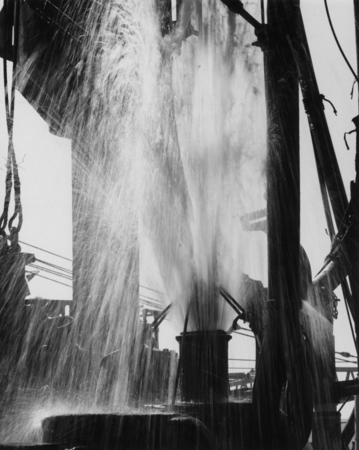 A gush of seawater erupts on the drill floor of the D/V Glomar Challenger (ship) as crewmen pull pipe with a stock core ba...