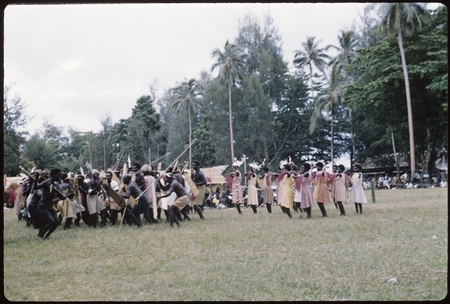 Dancers with shields and spears, with women dancers to the right