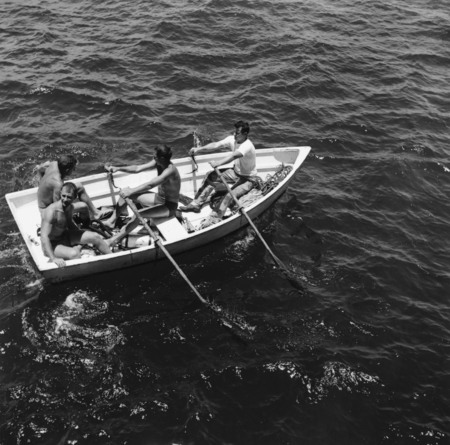 Four men row a skiff during the Capricorn Expedition