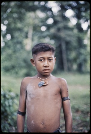 Boy with necklaces, woven armband, and talcum powder on chest