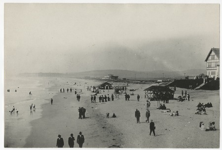People walking along beach near Del Mar plunge and bathhouse