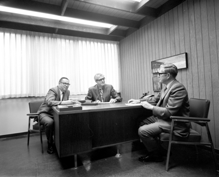 Roy Greaves, Willis Bergeson, and George Matson at desk, Purchasing Department, UC San Diego