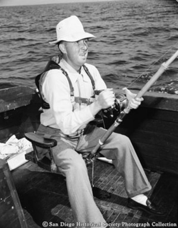 Sportfisherman on boat sitting in swivel seat with rod
