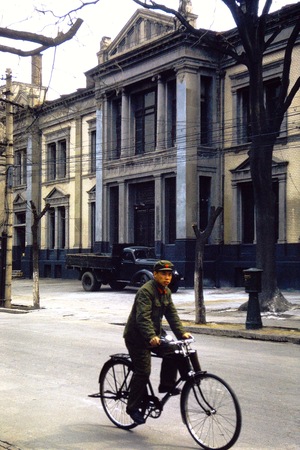 Beijing, western-style building and a PLA soldier riding a bike