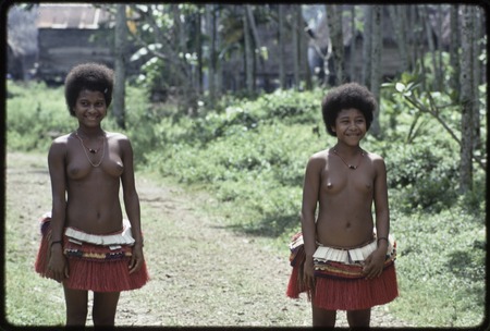 Adolescent girls wearing short red fiber skirts and shell necklaces