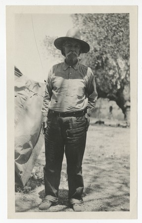 Man in straw hat standing near canvas tent