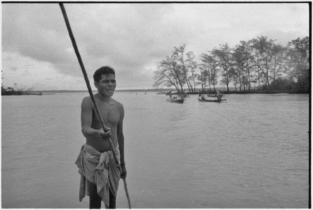 Fishing: men return to beach canoes in lagoon