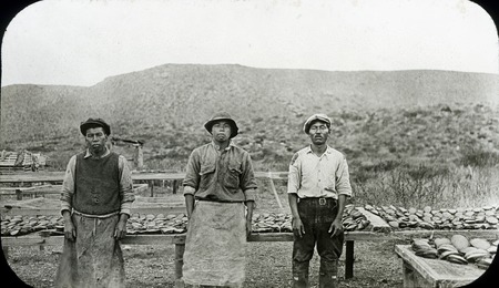 Three Japanese fishermen at the abalone camp #1 with drying racks in background, located south of Ensenada Bay