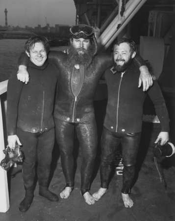 Divers in wetsuits on the deck D/V Glomar Challenger (ship) during the Deep Sea Drilling Project. December 7, 1977.
