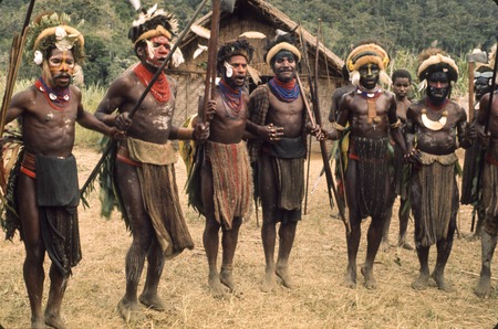 Decorated men practice dancing and chanting in advance of a ceremony