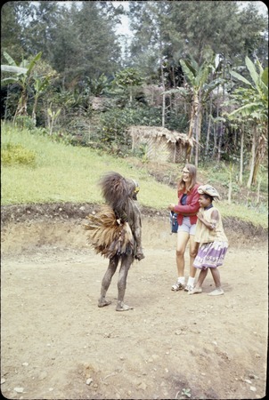 Ery Ben, costumed as a Narak clown, engages Susan Pflanz-Cook and girl, Mbopo