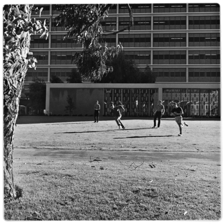 Students playing football on lawn outside Urey Hall