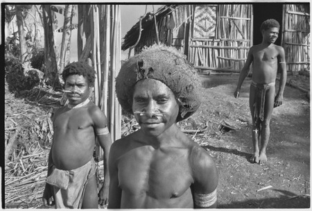 Adolescent boys with pierced noses, one in barkcloth cap, stand near the Rappaports&#39; house