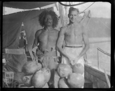 Solomon islander and European man holding coconuts