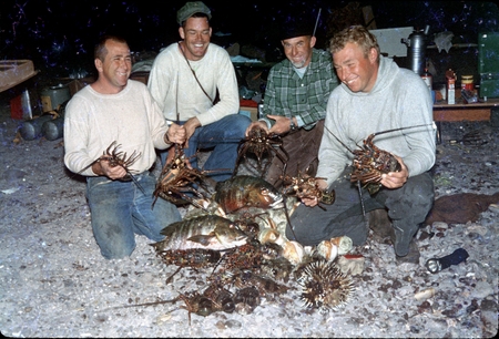 James Ronald Stewart (far left), shown here with three unidentified men showing off their catch for the day, including som...