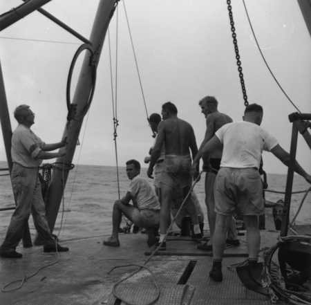 John Dove Isaacs (left) feeds wire out with Willard Bascom (center, squatting down and looking back), aboard R/V Spencer F...
