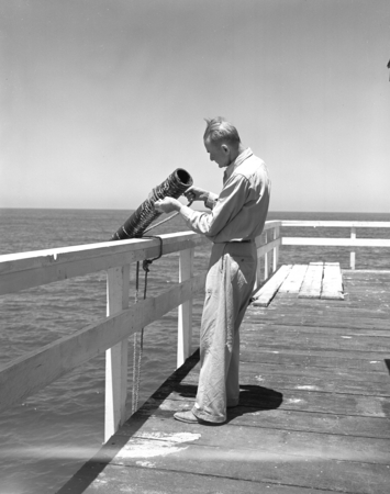 Laboratory assistant Claude Palmer with octopus trap on the Scripps Institution of Oceanography pier