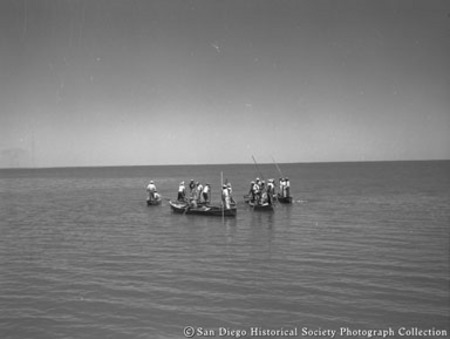 View from American Agar Company boat of men poling small boats off coast of Baja California