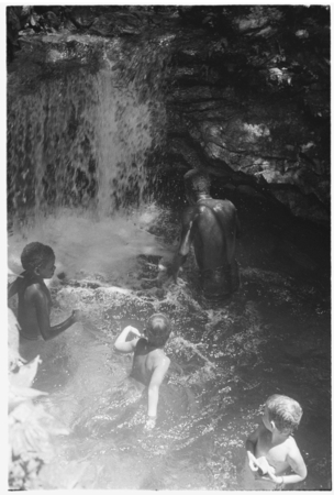 People, including Keesing&#39;s daughters, in pool of water, waterfall.