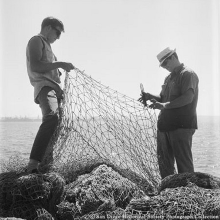 Two men repairing fishing net