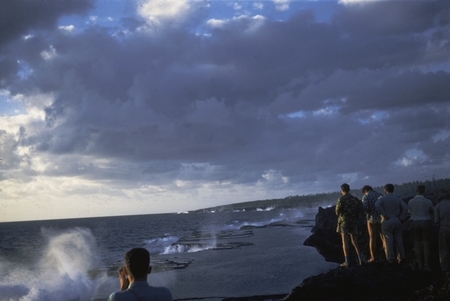 Ten feet above the ocean, members of the Capricorn Expedition (1952-1953) are viewing Mapu a Vaea or &#39;Whistle of the Noble...