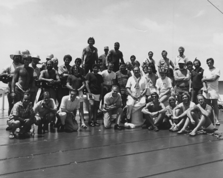 Scientists, technicians, and all other crew members pose with Joe Clarke (center - kneeling with folded arms), the captain...