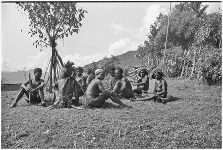 Men on grounds of government rest house in Tsembaga, their bows and arrows propped beside them