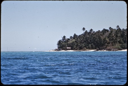 Kaileuna Island: distant view of village, beach, and palm trees