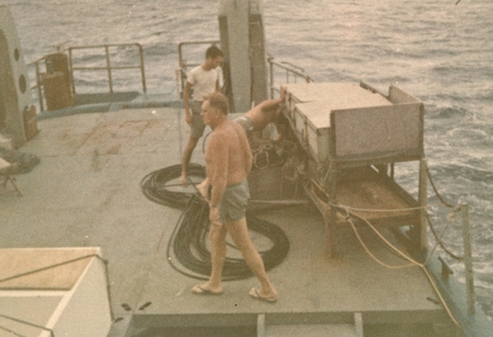 George W. Hohnhaus (foreground) on R/V Horizon, putting the magnetometer fish into the water and paying out endless cable....