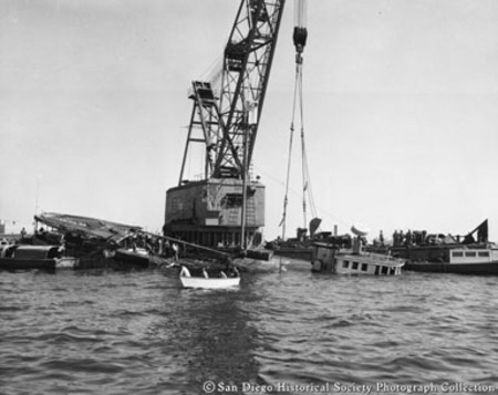 Crane on dock raising sunken tuna boat Normandie