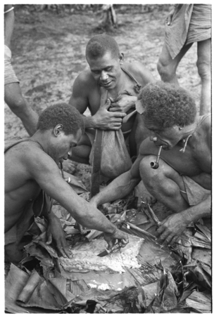 Men eating gwasu taro and coconut pudding.