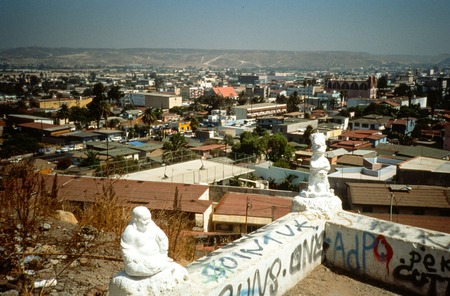 Stairway of the Ancients: Upper level view of Tijuana with Buddha and Bart Simpson