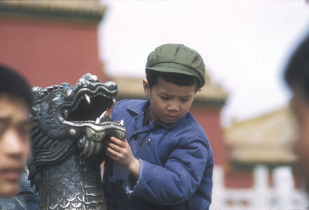 Boy Playing on Dragon Stature at Forbidden City