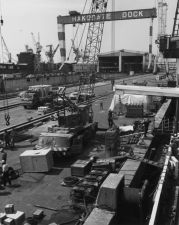 Dock-side work and workers near the D/V Glomar Challenger (ship) in Hokadate, Japan, during Leg 88 of the Deep Sea Drillin...
