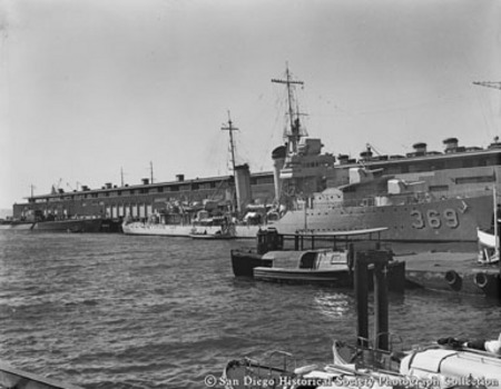 U.S. Navy warship and submarine Nautilus docked along pier in San Diego harbor