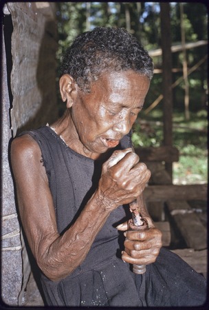 Bomtavau uses mortar and pestle to crush betel nut