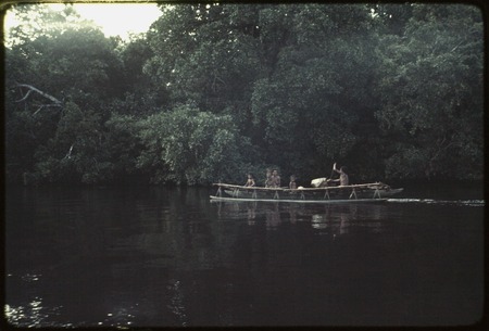 Canoe used as transport, man paddles, woman and children are passengers